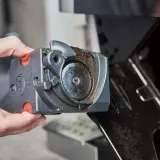 Dłoń wyjmuje brudny moduł młynka do kawy z ekspresu DeLonghi. Czas na czyszczenie, by cieszyć się aromatem!